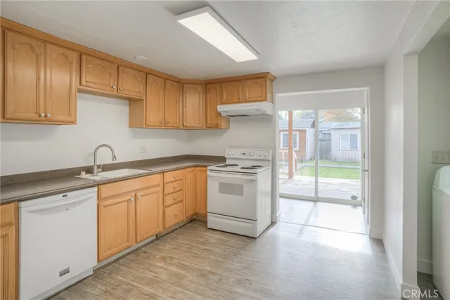 a kitchen with granite countertop a sink stainless steel appliances and cabinets