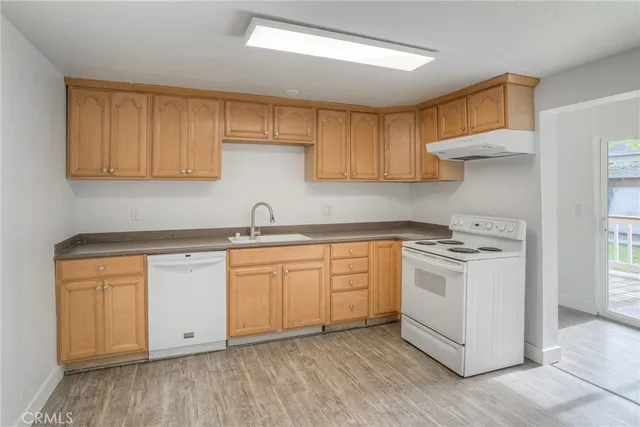 a kitchen with granite countertop white cabinets and white appliances