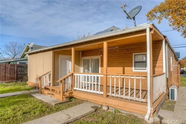 a view of a house with a small yard and wooden floor and fence