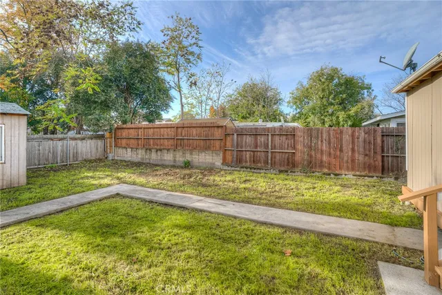 a view of a backyard with a small cabin and wooden fence