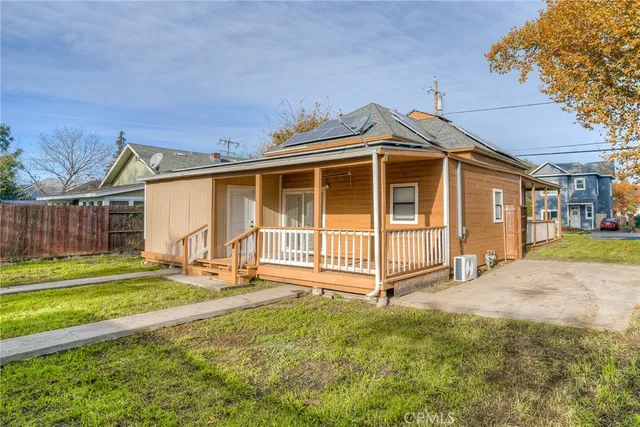a view of a house with backyard and wooden fence