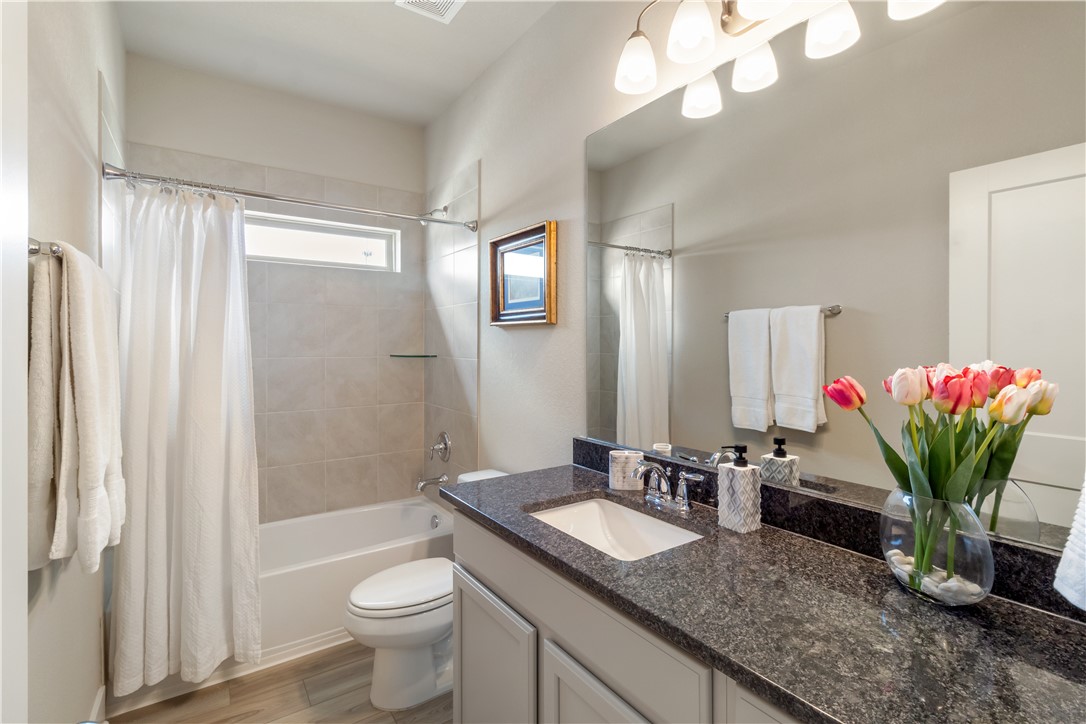 6303 Raleigh Drive College Station, TX 77845 - Photo 13 of 23 a bathroom with a granite countertop sink a toilet and a mirror