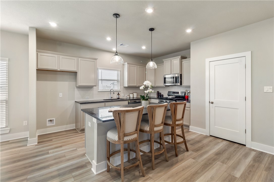 6303 Raleigh Drive College Station, TX 77845 - Photo 2 of 23 a kitchen with stainless steel appliances granite countertop a dining table chairs refrigerator sink and cabinets