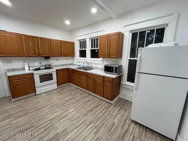 a kitchen with stainless steel appliances granite countertop a stove a sink dishwasher a refrigerator and a microwave