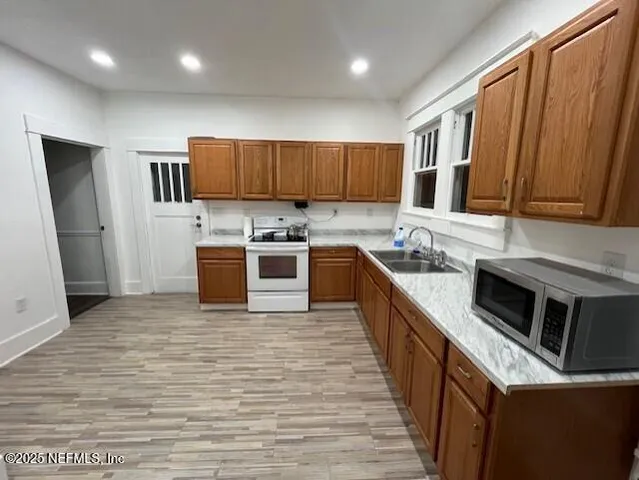 a large kitchen with stainless steel appliances granite countertop a stove a sink dishwasher and a refrigerator