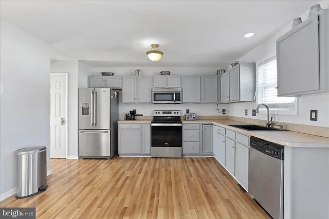 a kitchen with refrigerator a microwave and cabinets