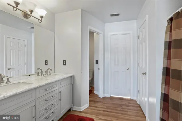 a spacious bathroom with a granite countertop sink a mirror and a shower