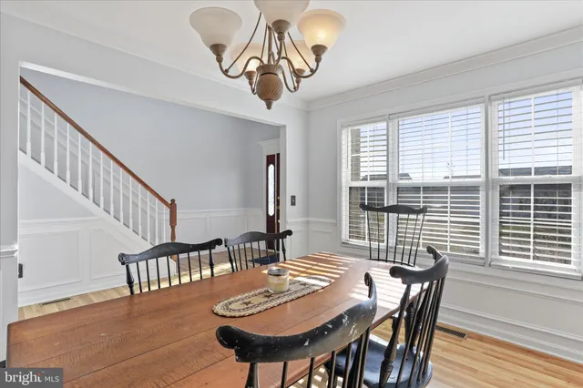 a view of a dining room and livingroom with furniture window and wooden floor