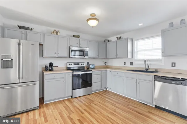 a kitchen with cabinets stainless steel appliances and window