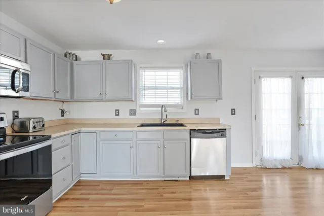 a kitchen with stainless steel appliances granite countertop a sink stove and cabinets