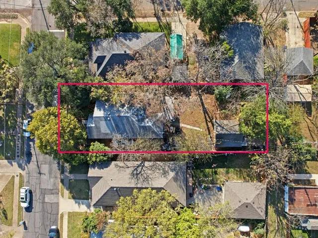 a view of a wooden house with large trees and wooden fence