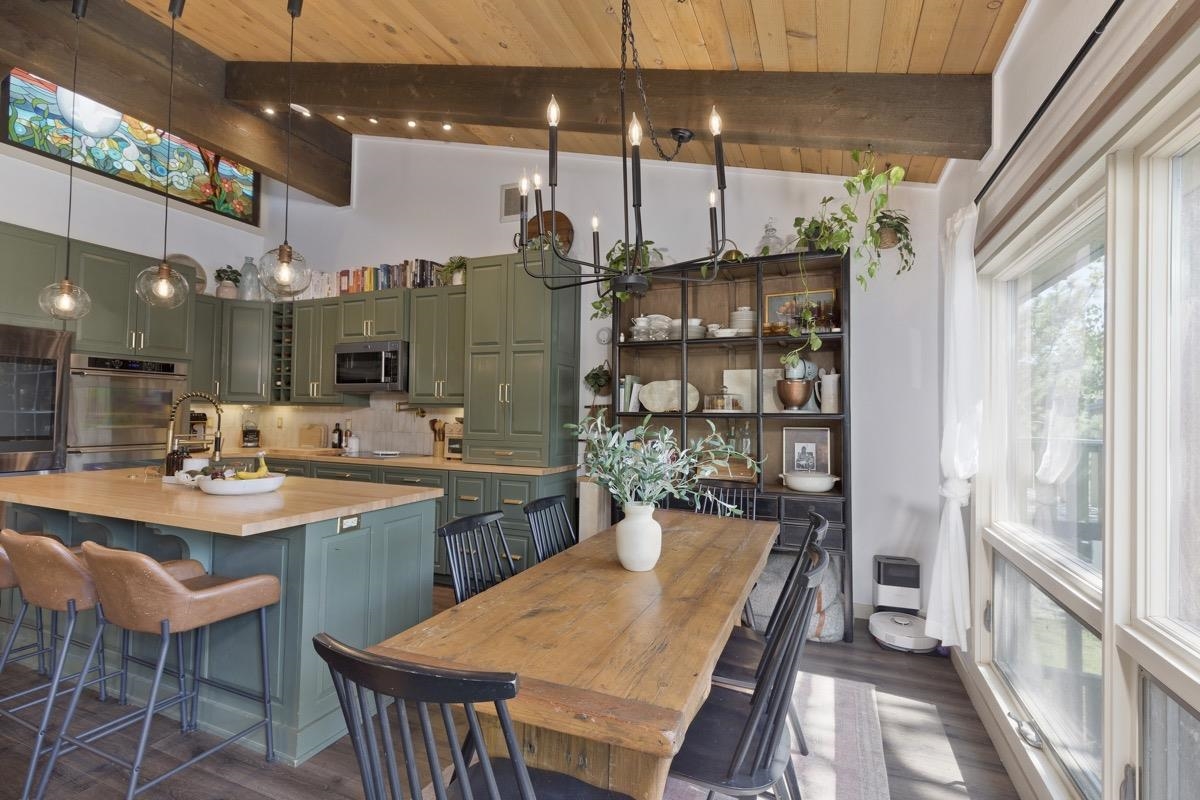 a dining room with stainless steel appliances kitchen island a table and chairs