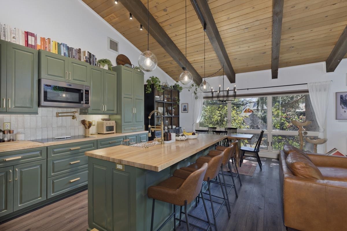 3251 Chateau Road, Unit 12 Mammoth Lakes, CA 93546 - Photo 2 of 50 a open kitchen with stainless steel appliances granite countertop a stove top oven a sink dishwasher a dining table and chairs with wooden floor