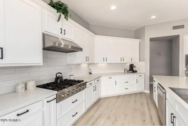 a kitchen with stainless steel appliances a sink a stove and cabinets