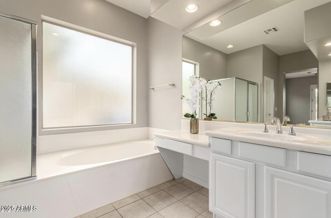 1515 North Los Alamos Circle Mesa, AZ 85213 - Photo 16 of 39 a bathroom with a bathtub a double vanity sink and mirror