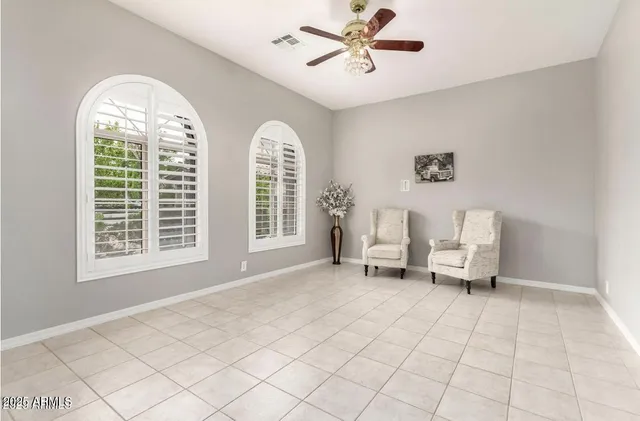 an empty room with a ceiling fan and window