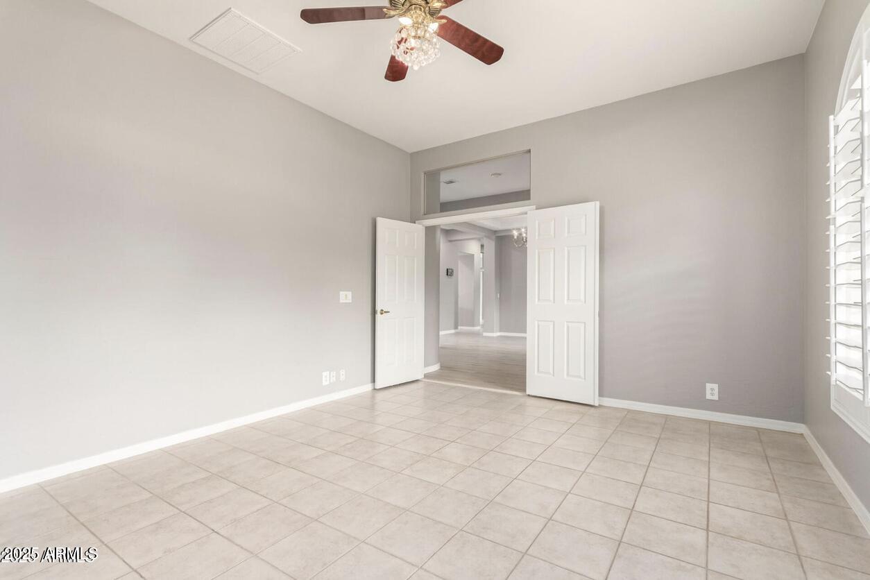 1515 North Los Alamos Circle Mesa, AZ 85213 - Photo 28 of 39 an empty room with a ceiling fan and window