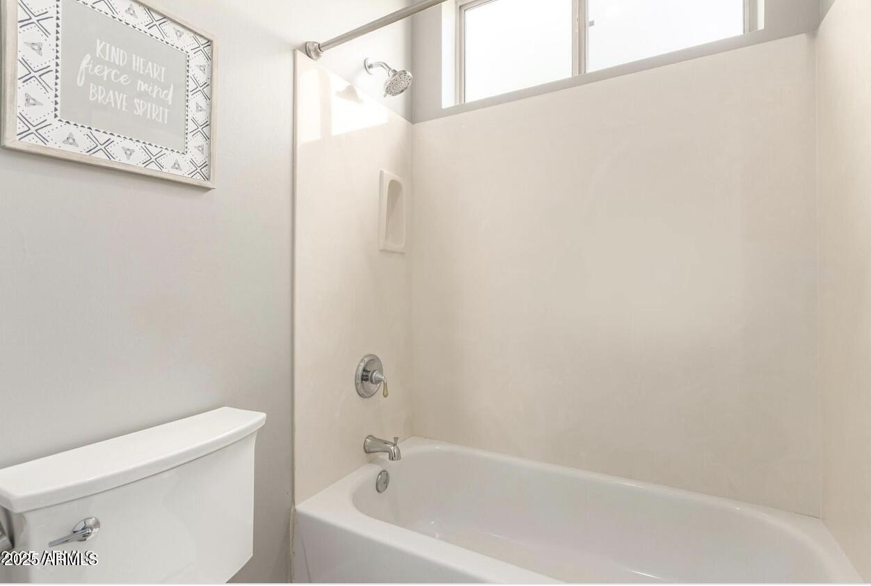1515 North Los Alamos Circle Mesa, AZ 85213 - Photo 30 of 39 a white bath tub sitting next to a white toilet and vanity