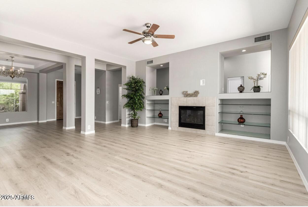 1515 North Los Alamos Circle Mesa, AZ 85213 - Photo 4 of 39 a view of a livingroom with a fireplace a chandelier and wooden floor