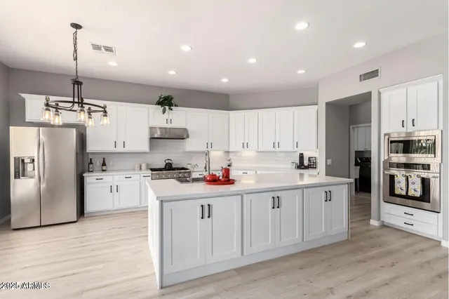 a kitchen with white cabinets and stainless steel appliances