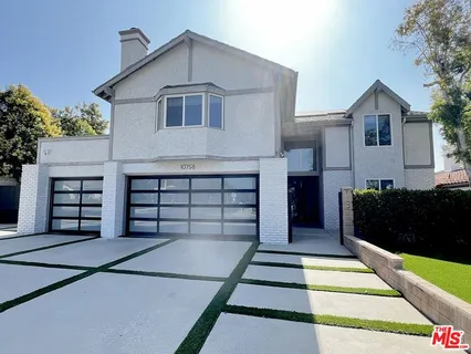 a view of a house with entryway and a yard