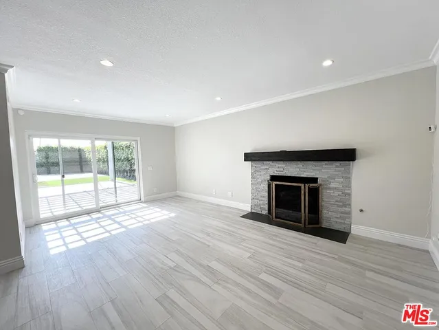 a view of a livingroom with wooden floor and a fireplace
