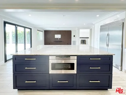 a kitchen with granite countertop a sink cabinets stainless steel appliances and a counter space