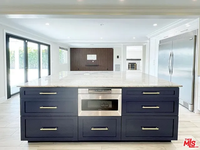 a kitchen with granite countertop a sink cabinets stainless steel appliances and a counter space