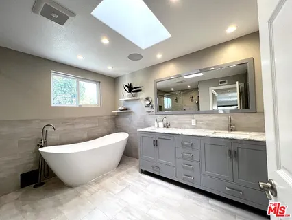 a bathroom with a double vanity sink toilet mirror and shower