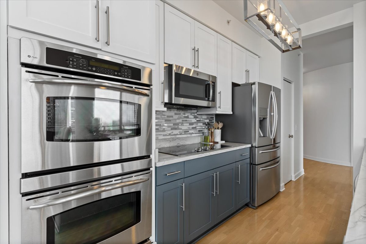 1235 South Prairie Avenue, Unit 2709 Chicago, IL 60605 - Photo 19 of 46 a kitchen with stainless steel appliances and chandelier