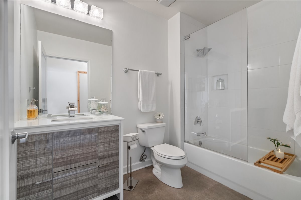 1235 South Prairie Avenue, Unit 2709 Chicago, IL 60605 - Photo 30 of 46 a bathroom with a granite countertop sink toilet a mirror and shower