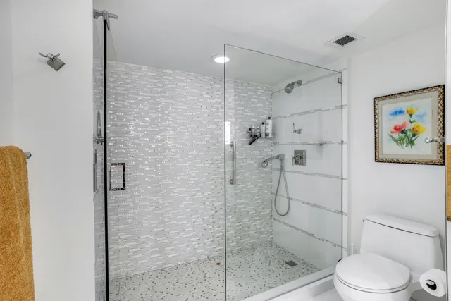 a bathroom with a shower a toilet and sink