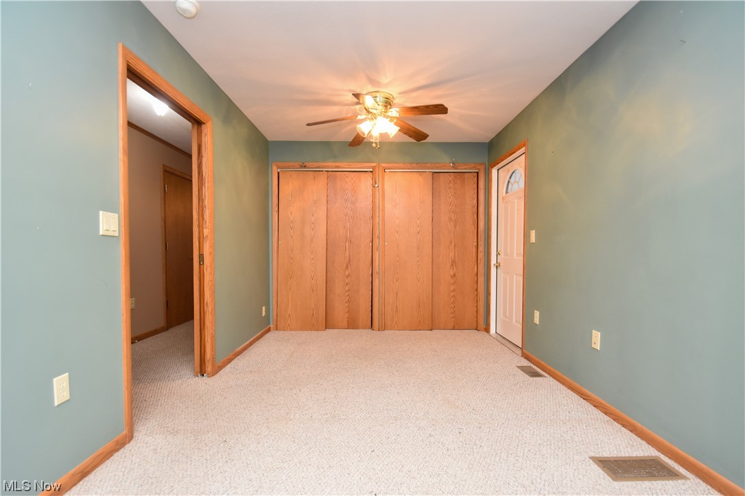 4606 Burkey Road Youngstown, OH 44515 - Photo 22 of 49 Unfurnished bedroom featuring light carpet, multiple closets, and ceiling fan