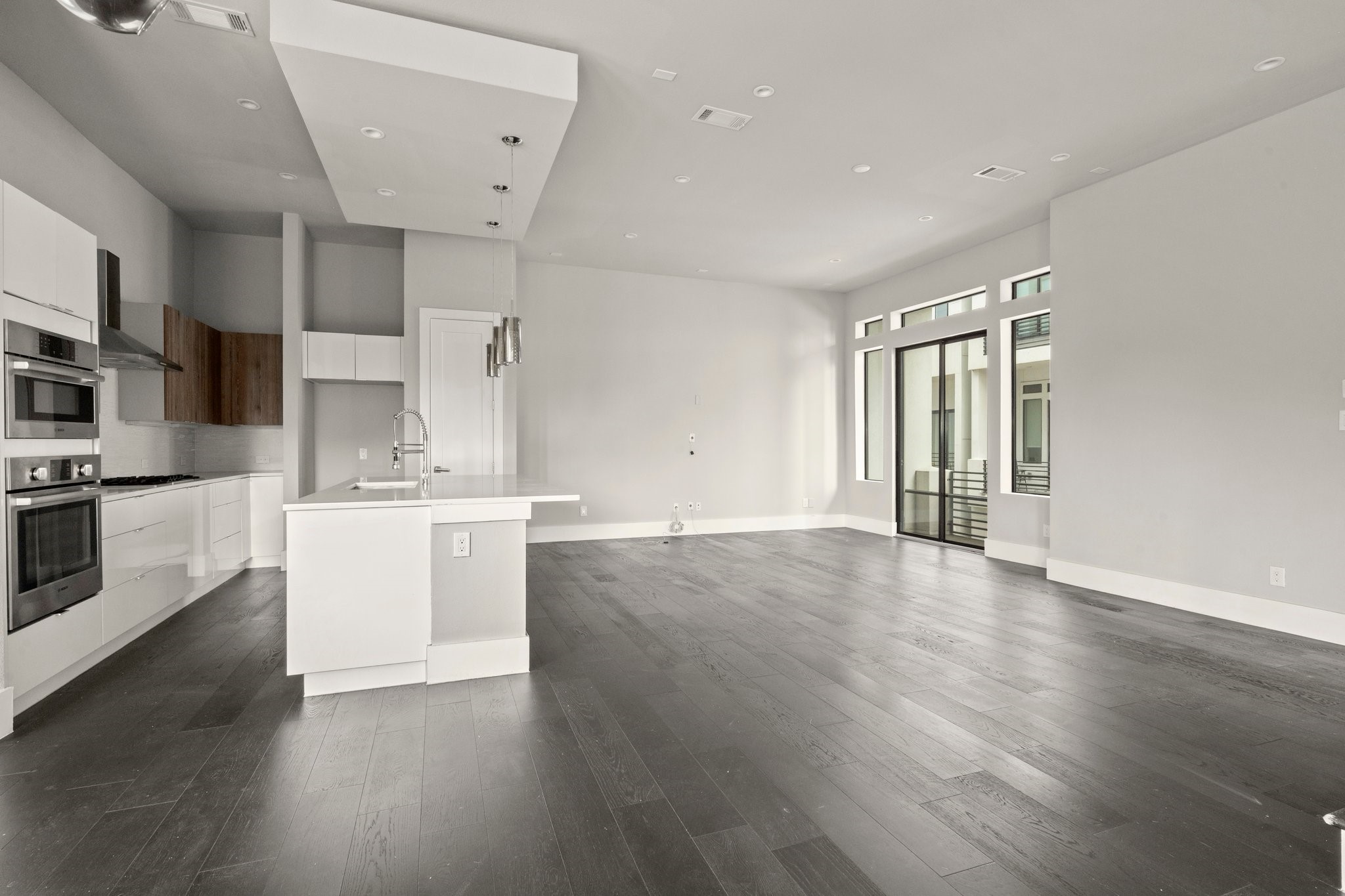 1615 Wheeler Avenue, Unit A Houston, TX 77004 - Photo 9 of 28 a large kitchen with stainless steel appliances wooden floors and white walls