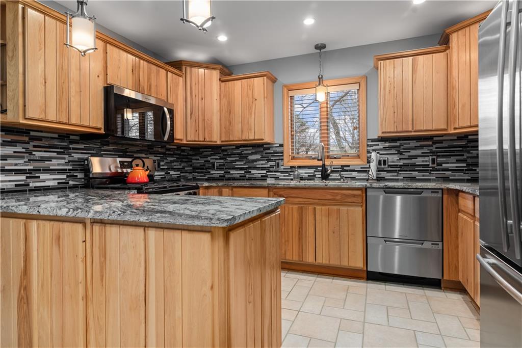7005 Franklin Road Cranberry Township, PA 16066 - Photo 9 of 26 a kitchen with stainless steel appliances granite countertop a stove a sink and a microwave