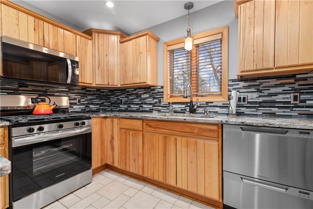 7005 Franklin Road Cranberry Township, PA 16066 - Photo 10 of 26 a kitchen with stainless steel appliances granite countertop a stove a sink and a microwave