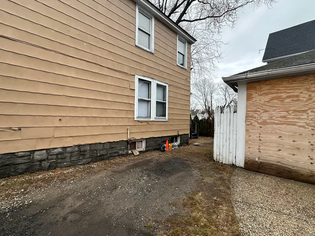 a view of a house with a small yard and wooden fence