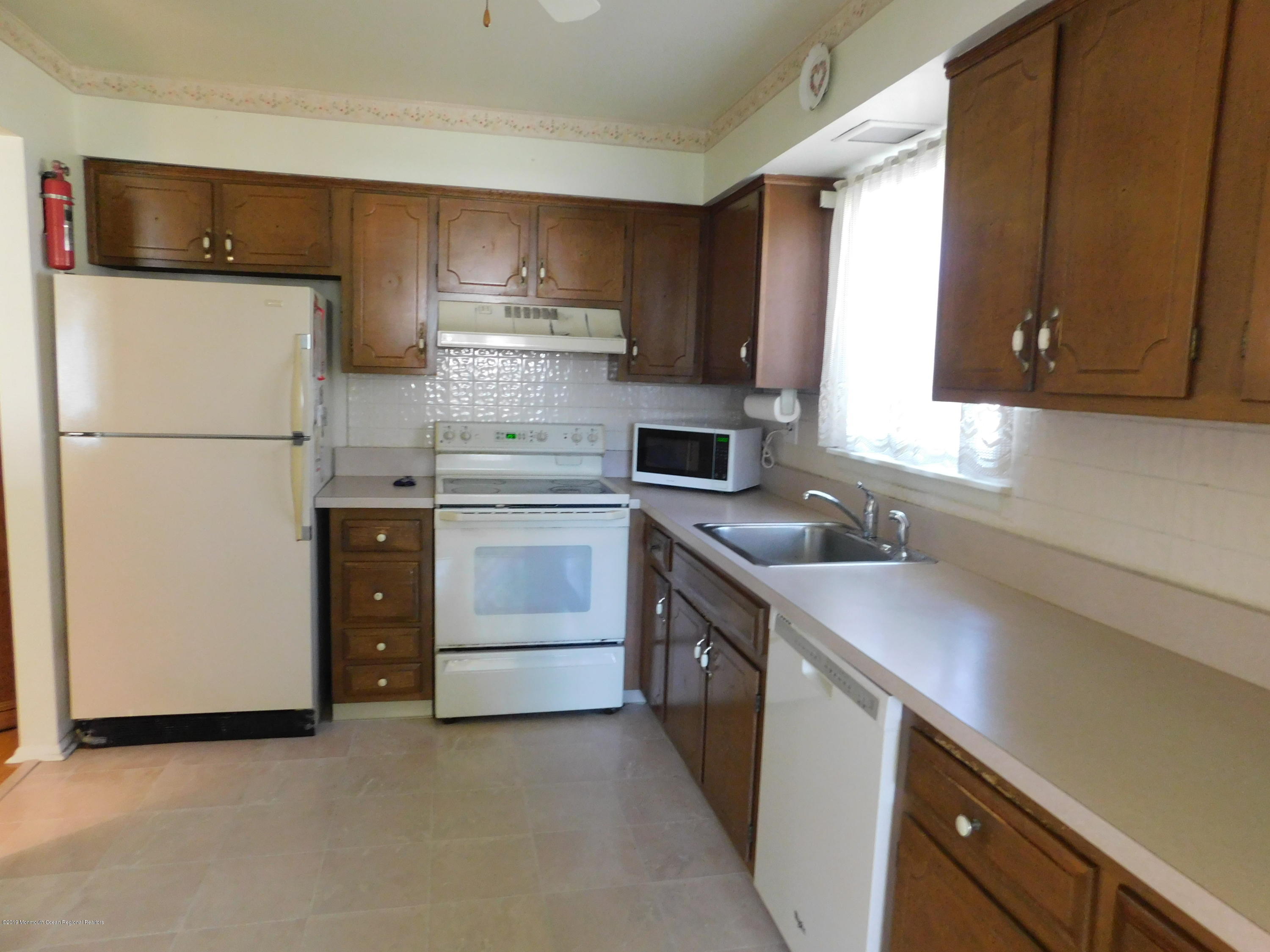26 Masters Road Brick, NJ 08724 - Photo 7 of 14 a kitchen with a sink a stove and a refrigerator
