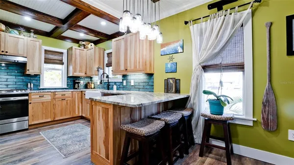 a kitchen with kitchen island granite countertop a table chairs in it and wooden floors
