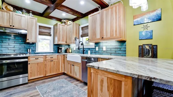 a kitchen with stainless steel appliances granite countertop a sink a stove and cabinets