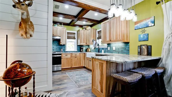 a kitchen with stainless steel appliances granite countertop a sink a stove and a wooden floors