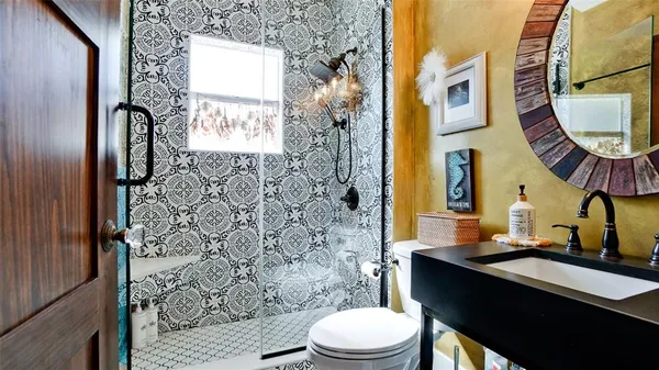 a bathroom with a sink a toilet and shower