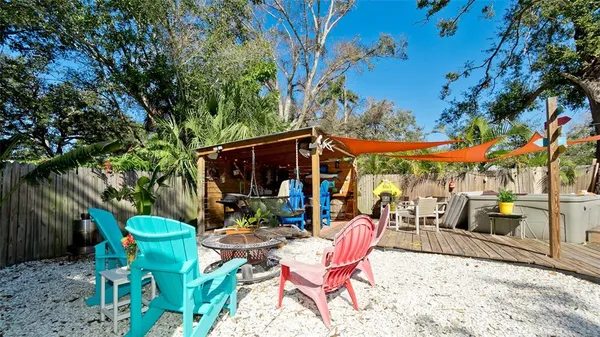 a view of a patio with table and chairs potted plants with wooden floor and fence