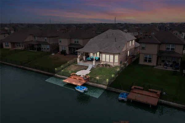 an aerial view of a house with backyard space and lake view