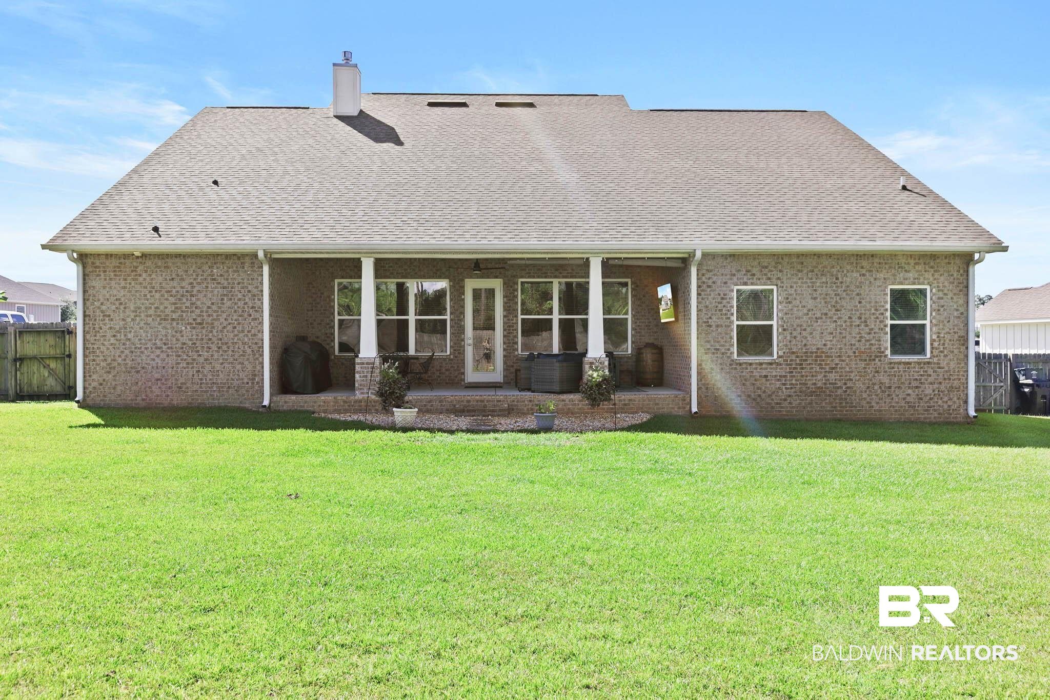 12785 Warbler Street Daphne, AL 36527 - Photo 41 of 53 Back of house featuring a patio, a chimney, brick siding, and roof with shingles