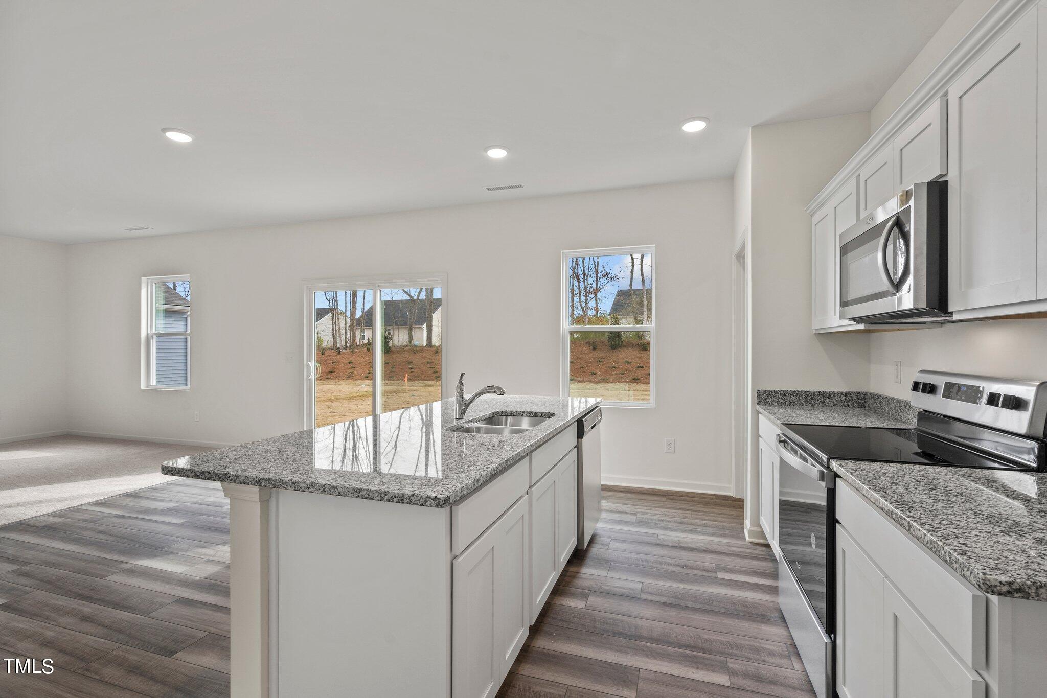 800 Piaggio Lane Spring Hope, NC 27882 - Photo 28 of 33 a kitchen with granite countertop a sink and a stove top oven