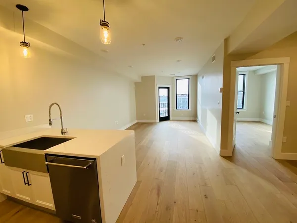 a view of a sink and dishwasher with wooden floor