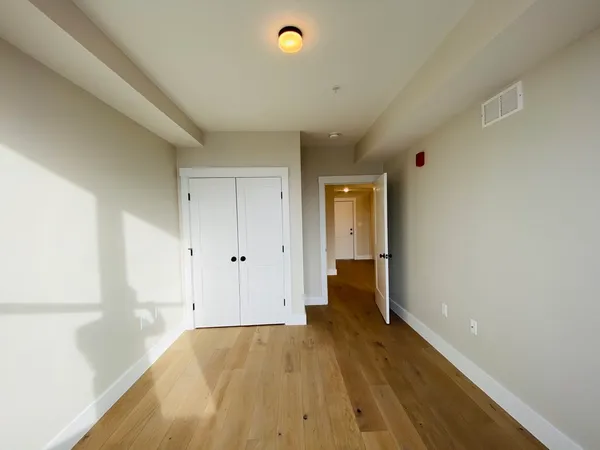 a view of a room with wooden floor and a window
