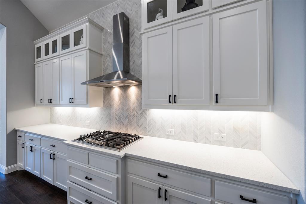 1650 Oakcrest Drive Prosper, TX 75078 - Photo 15 of 40 Kitchen featuring white cabinets, wall chimney range hood, decorative backsplash, and light stone countertops