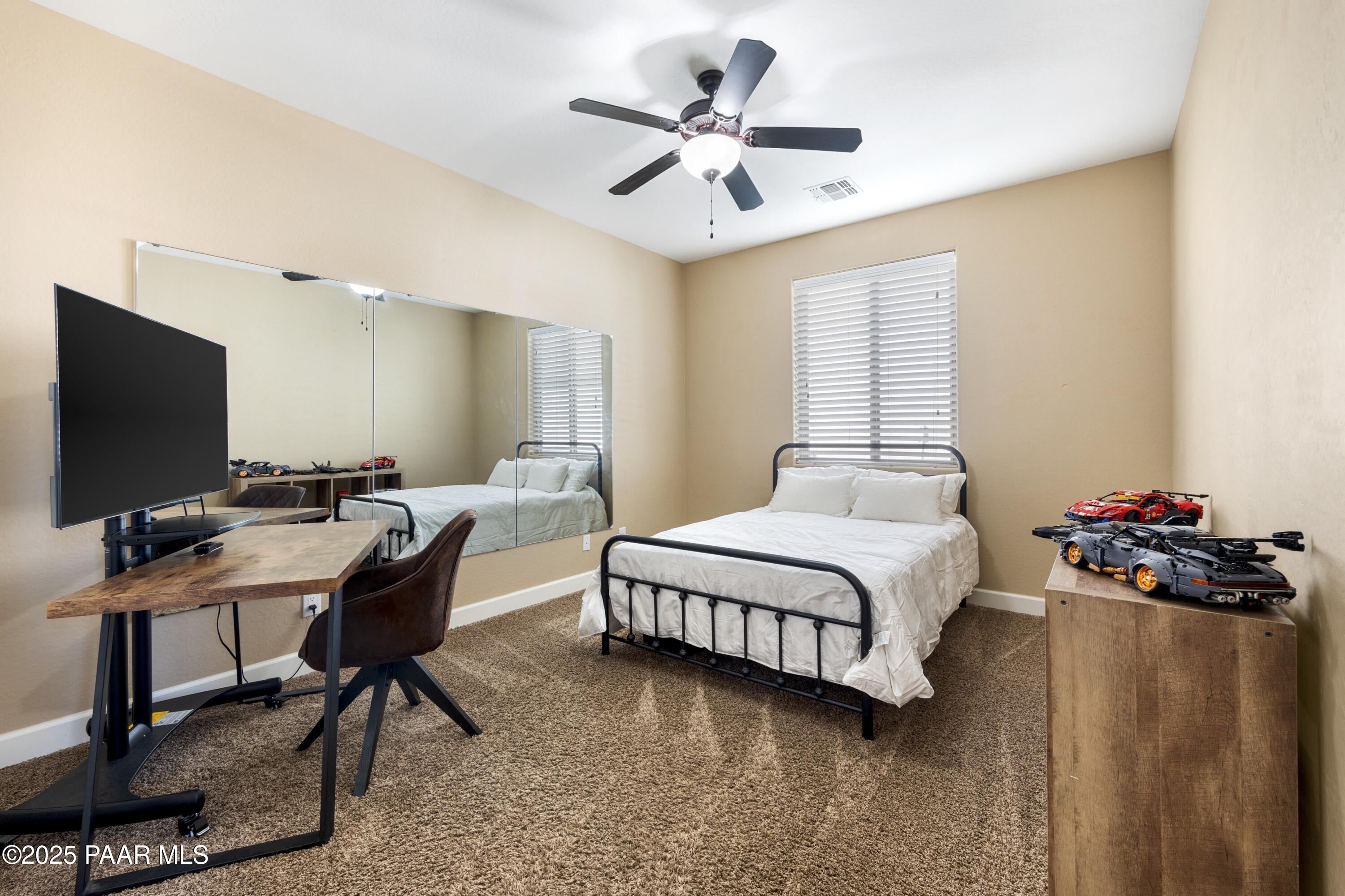 1200 Rusty Nail Road Prescott Valley, AZ 86314 - Photo 14 of 32 a bedroom with a bed desk and a window